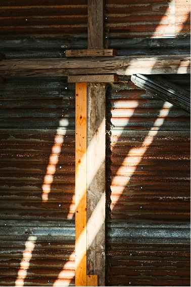 Light raking across the corrugated barn wall