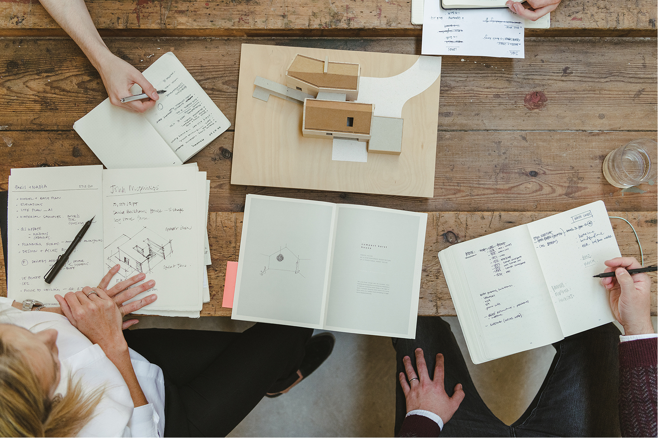 Design team working over sketches and the site model